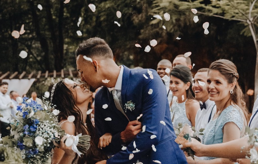 Bride and Groom kiss under confetti